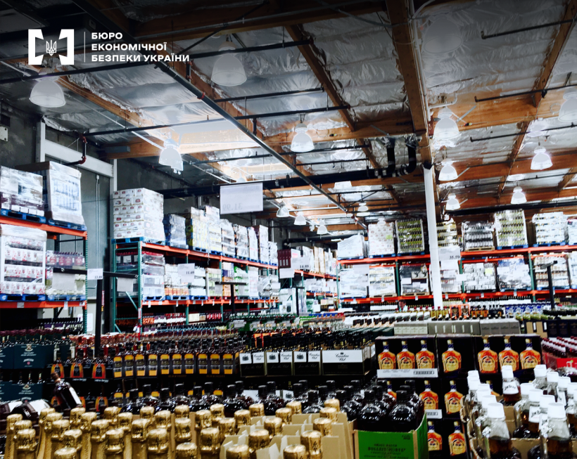 Склад алкогольної продукції. Велика кількість товарів в упаковці і без на підлозі та стелажах.