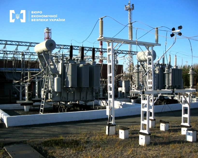 Електрична підстанція з трансформаторами, високовольтними лініями та металевими конструкціями на тлі блакитного неба