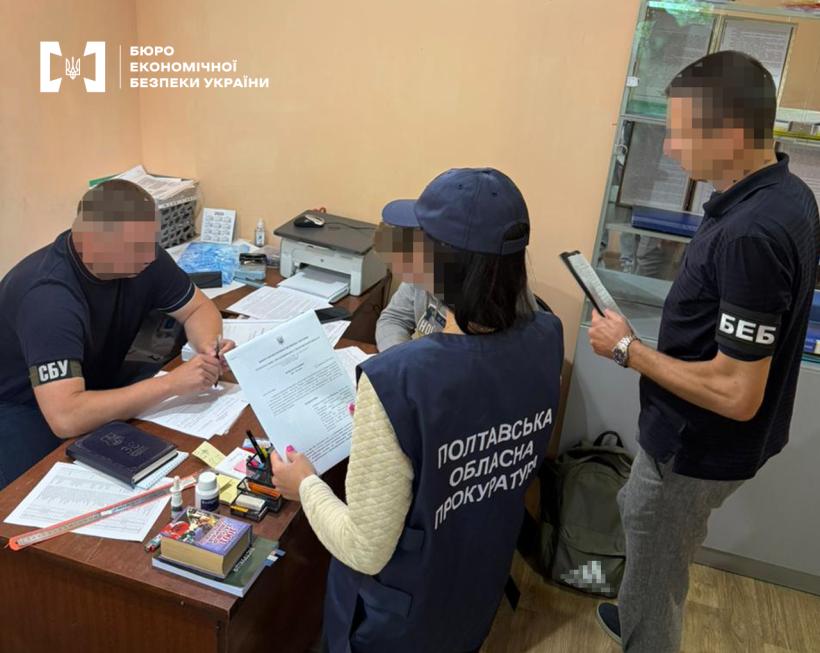 Працівники БЕБ та Полтавської обласної прокуратури повідомляють про підозру фігуранту справи у робочому кабінеті. Поруч за столом сидить працівник СБУ.