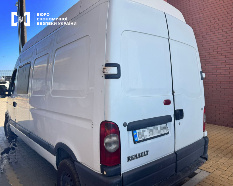 Білий вантажний мікроавтобус Renault припаркований біля цегляної стіни. Номерний знак заблюрено