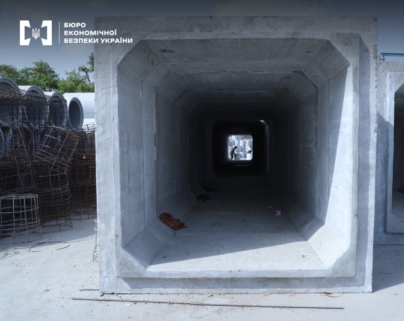 Великогабаритний залізобетонний елемент тунельного типу.  Поруч складені бетонні труби великого діаметру та арматурні заготовки.