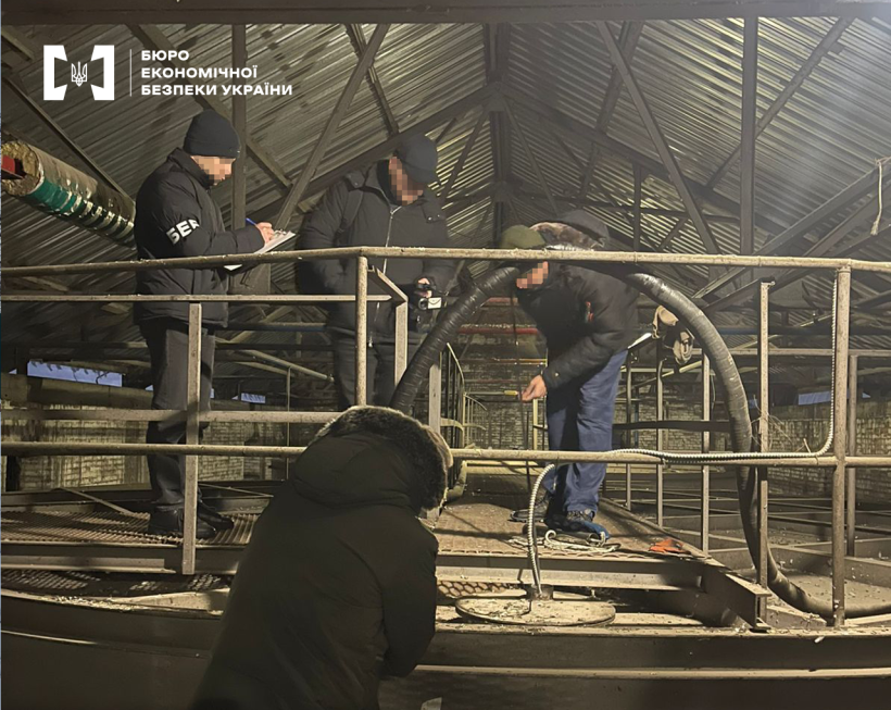 Детективи БЕБ оглядають приміщення заводу з виробництва етанолу. Промислові резервуари, труби, металеві конструкції.