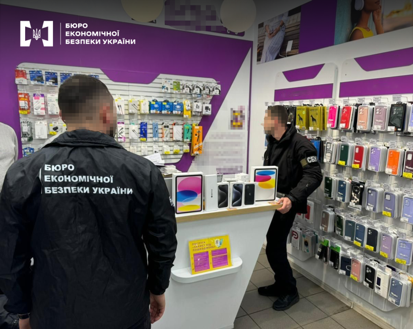 Працівники БЕБ та СБУ проводять обшук у магазині електроніки. На вітринах різні гаджети та аксесуари до них.