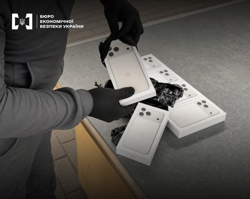 Hands in black gloves unbox white boxes with new iPhone 15 Pro smartphones during a search.
