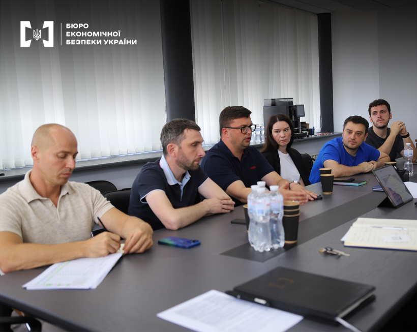 Конференцзал. Учасники зустрічі за столом. На столі документи, записники, смартфони, вода в ПЕТ пляшках. Триває обговорення.