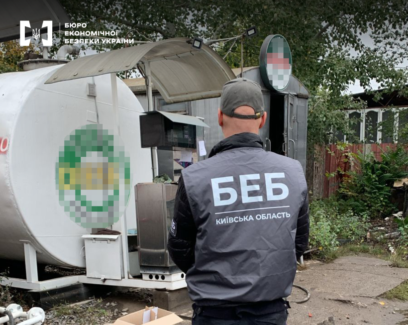Територія незаконної АЗС. Детектив БЕБ оглядає резервуар для зберігання пального та паливно-заправний комплекс