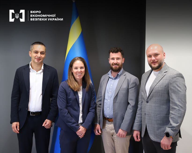 Director of the Economic Security Bureau of Ukraine Oleksandr Tsyvinskyi and his First Deputy Taras Shcherbai with representatives of the Embassy of the United States in Ukraine against the background of the Ukrainian flag.