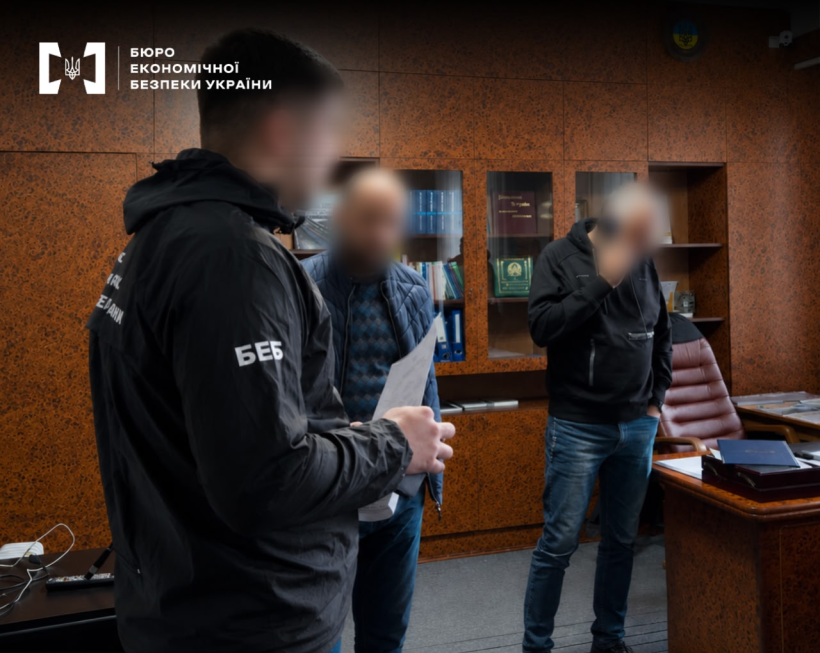 A ESBU detective serving suspicion notices to two men inside an office.