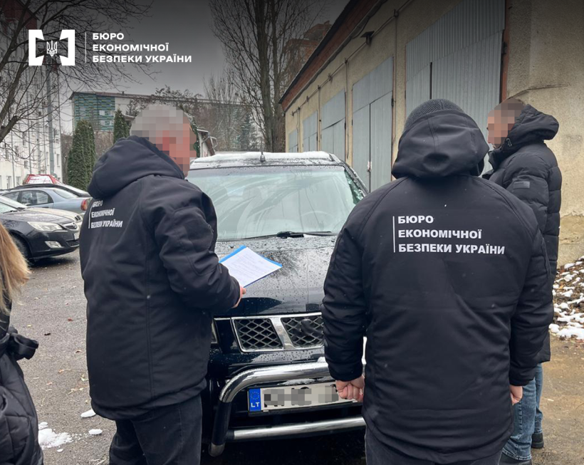 Два детективи БЕБ проводять вилучення чорного позашляховика. Гаражі, припарковані авто, кілька дерев