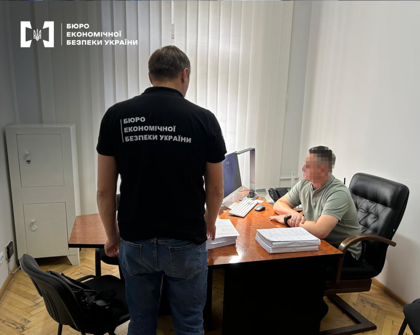 Робочий кабінет. Детектив БЕБ вручає підозру фігуранту справи.