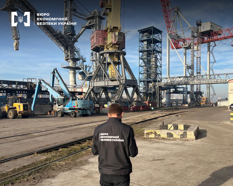 Детектив БЕБ на території порту. Великі портові крани, вантажна техніка.