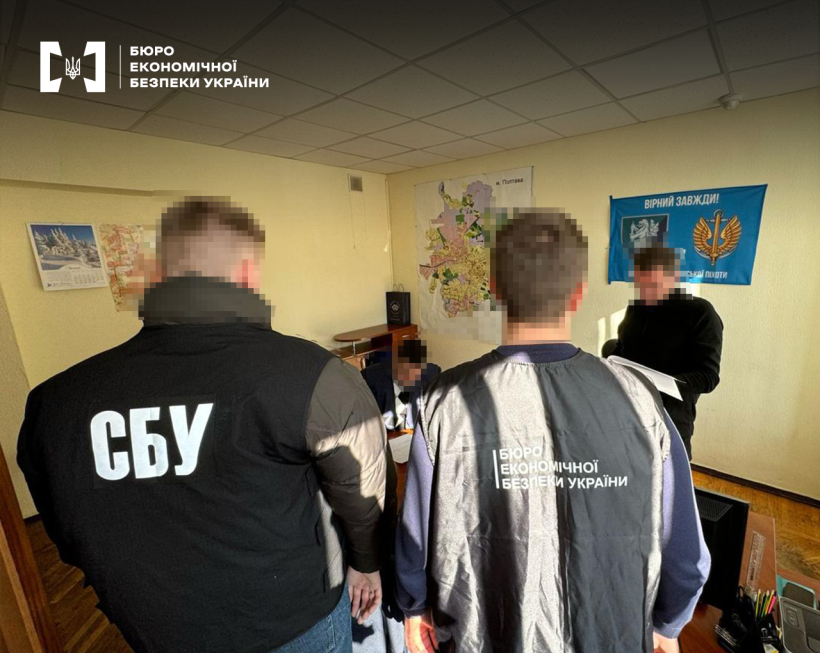 Працівники БЕБ та СБУ вивчають документи під час обшуку офісного приміщення.