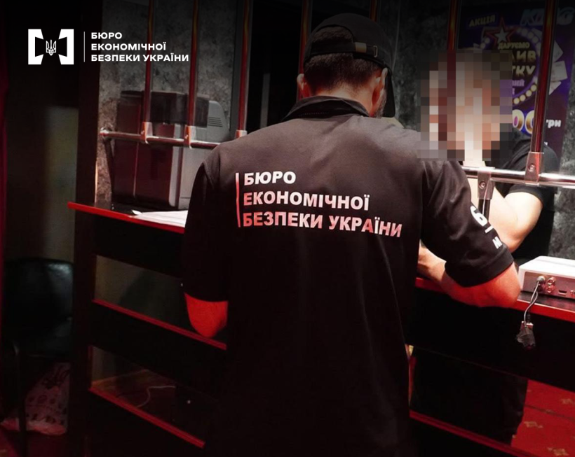 Детектив БЕБ проводить обшук за стійкою в нелегальному гральному закладі