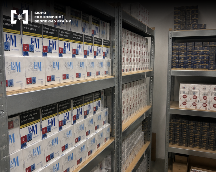 Metal shelving units in a warehouse tightly packed with cartons of L&M and other cigarette brands.