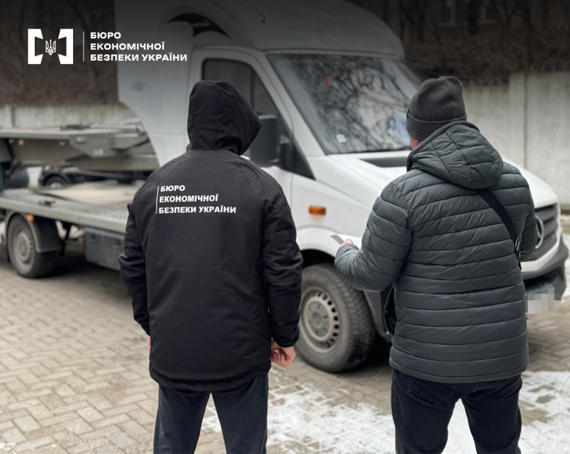 Два детективи БЕБ оглядають евакуатор білого кольору