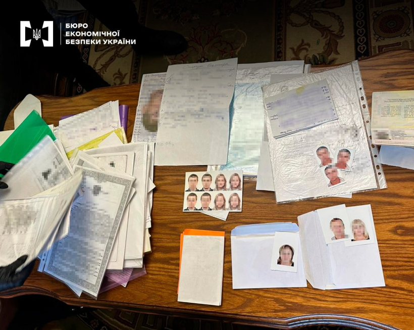 Копії документів, фотографії чоловіків і жінок для документів, конверти, паспорти розкладені на дерев'яному столі