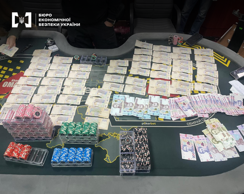 Гральні фішки різних кольорів, банкноти номіналом 1000, 500, 200 та 100 грн, розкладені на столі для гри в покер