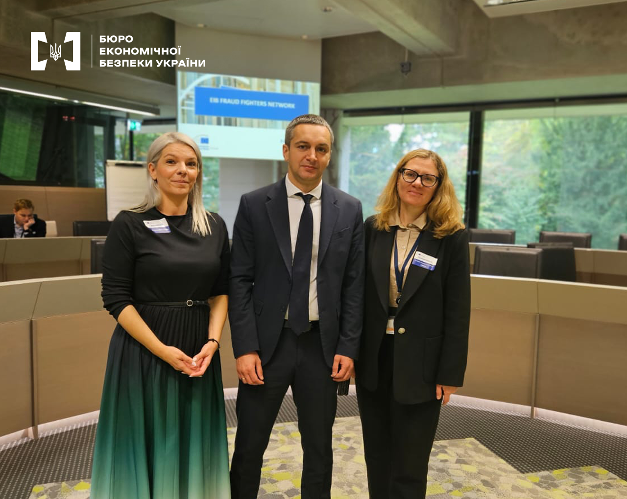 A photo of three participants in a conference room (a man in the center, women on both sides). A screen in the background reads “EIB Fraud Fighters Network.”