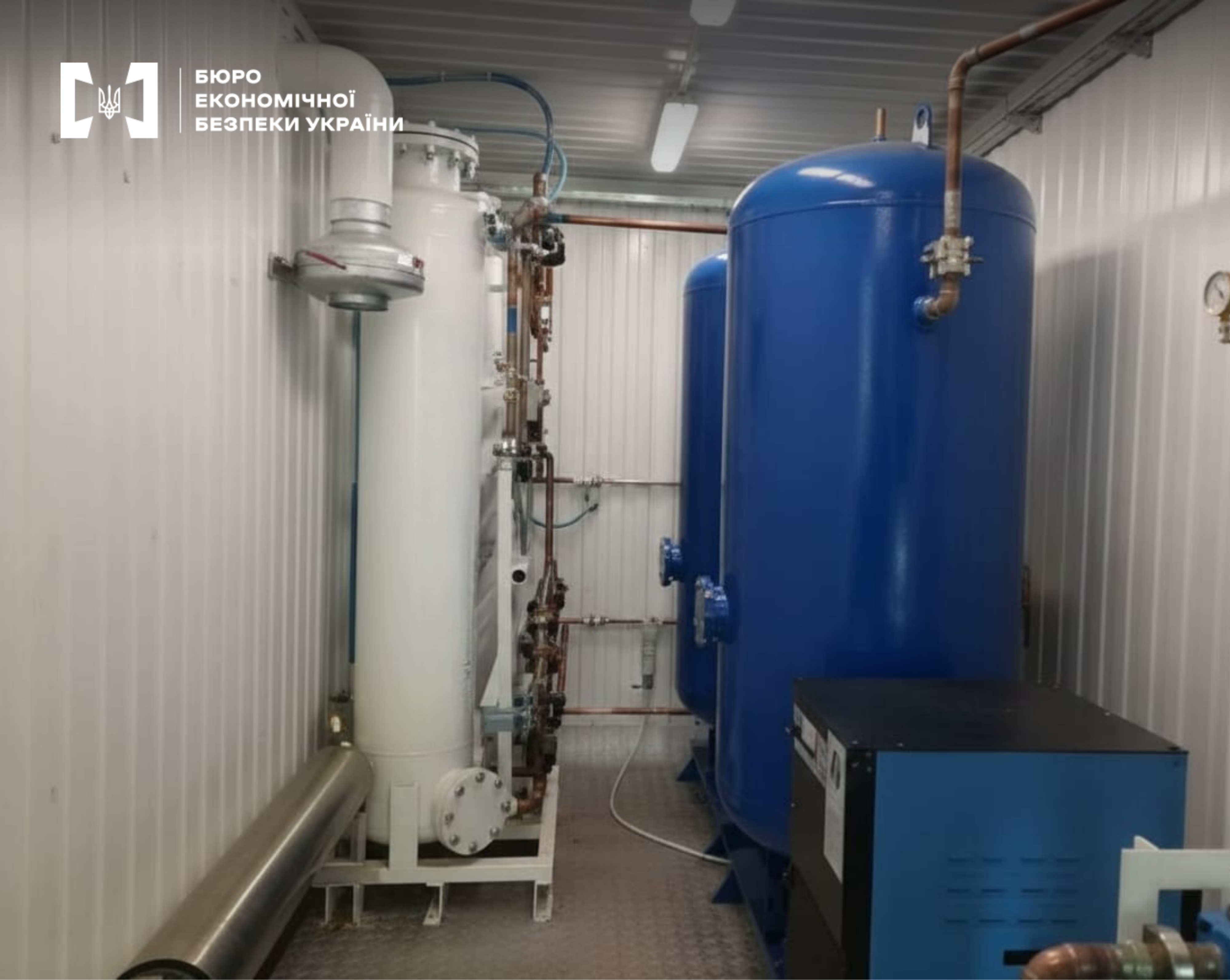 Технічне світле приміщення з системою для очищення та зберігання газів. Сині та білі резервуари з численними трубками та індикаторами.