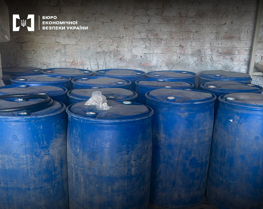 Rows of dirty blue barrels with alcohol or fuel against the background of a brick wall in an abandoned room