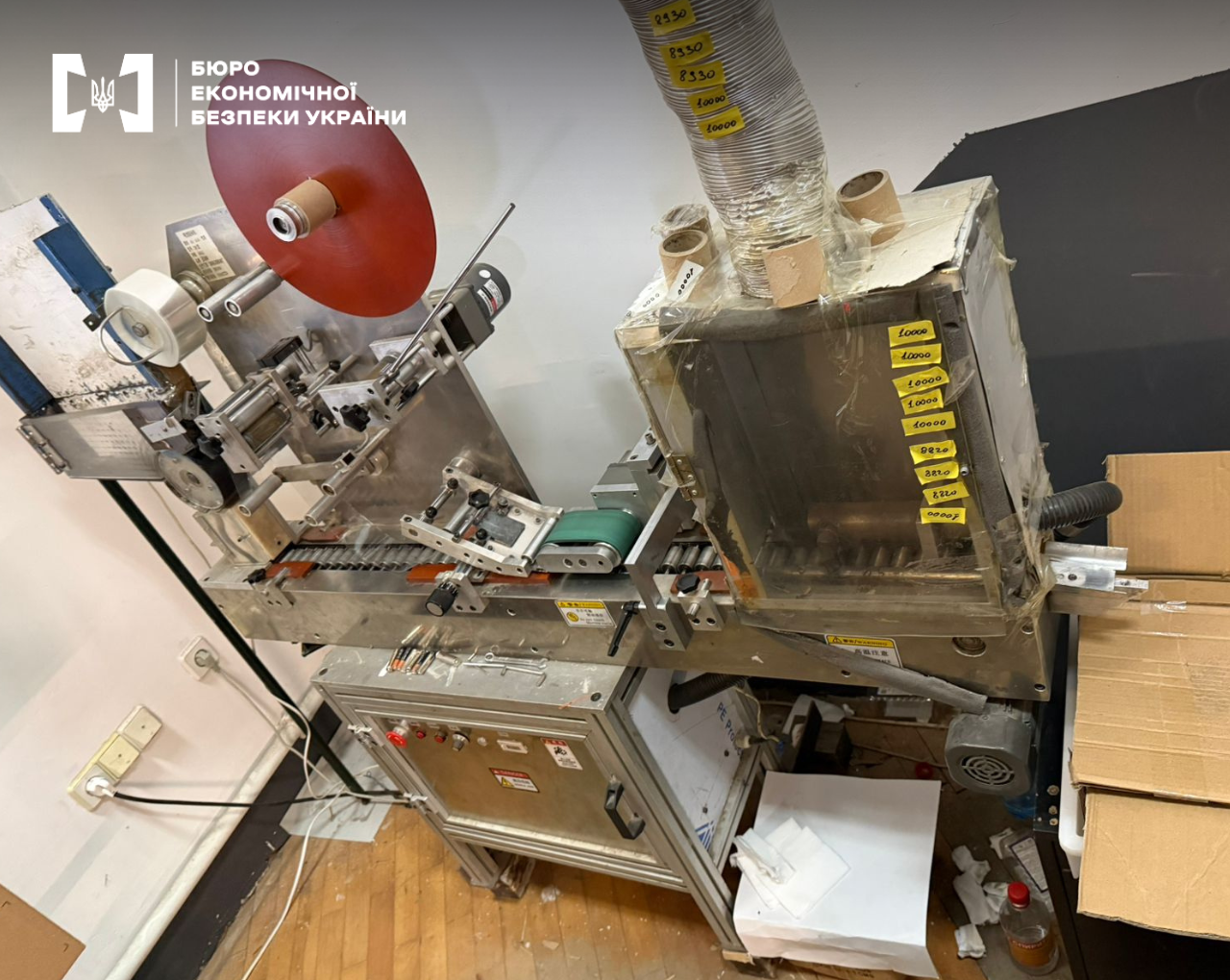 Industrial equipment with tape reels and stickers in an underground workshop.