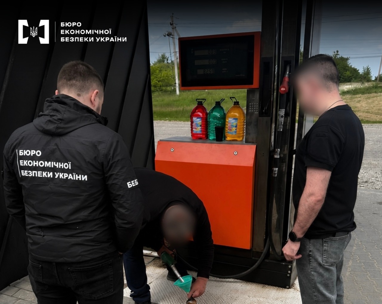 ESBU detectives inspect a fuel dispenser at a gas station in the presence of a man.