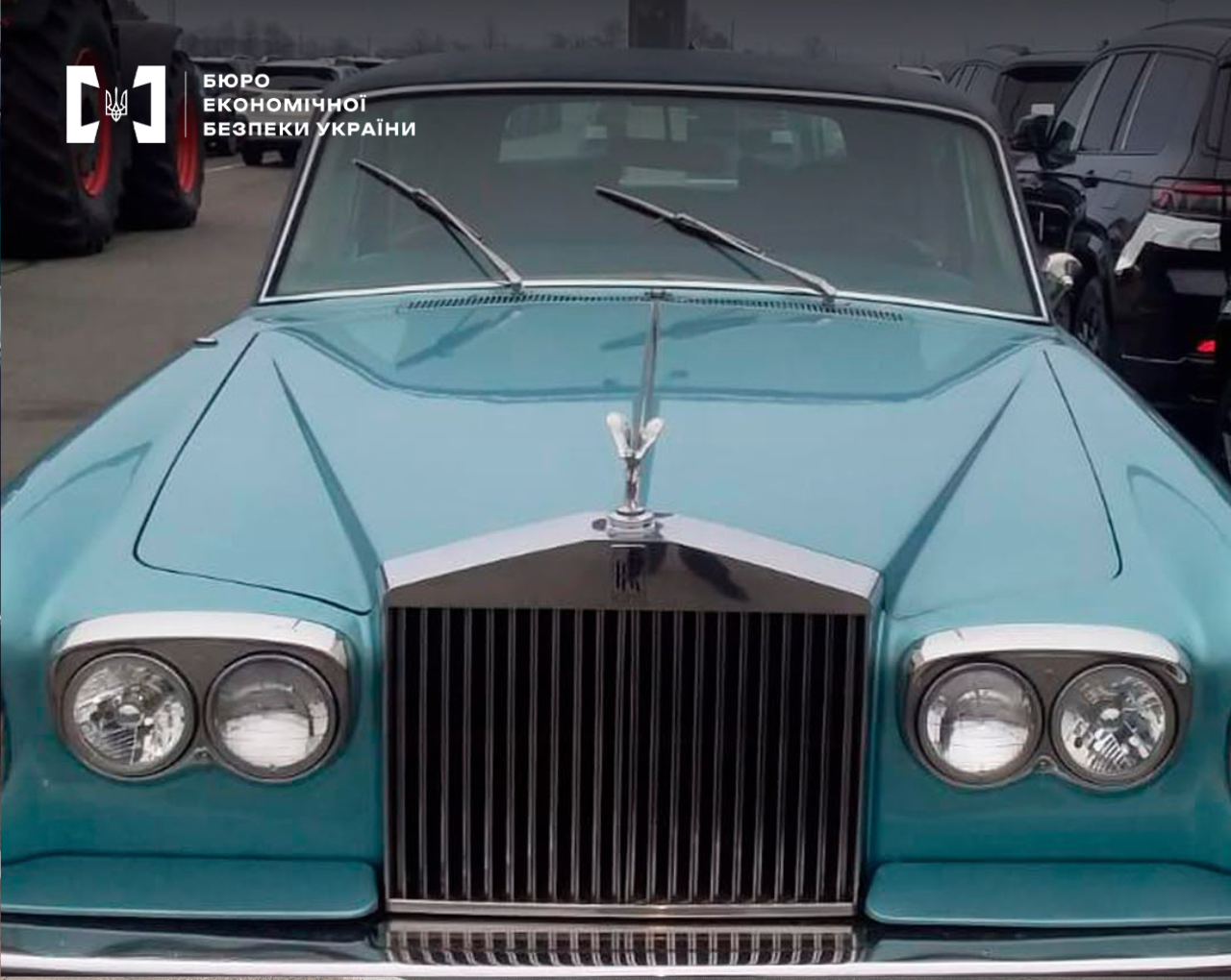 The front part of a vintage Rolls-Royce with a chrome radiator grille and a statuette on the hood.