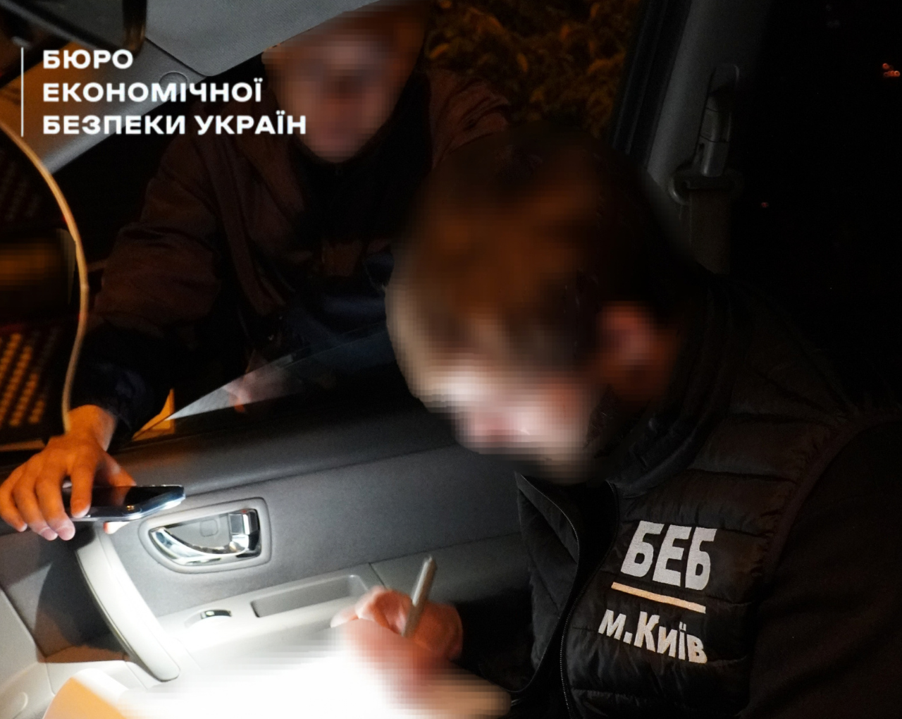 A ESBU detective documents the suspect's signatures on papers inside a car cabin during a nighttime detention. The faces are blurred.