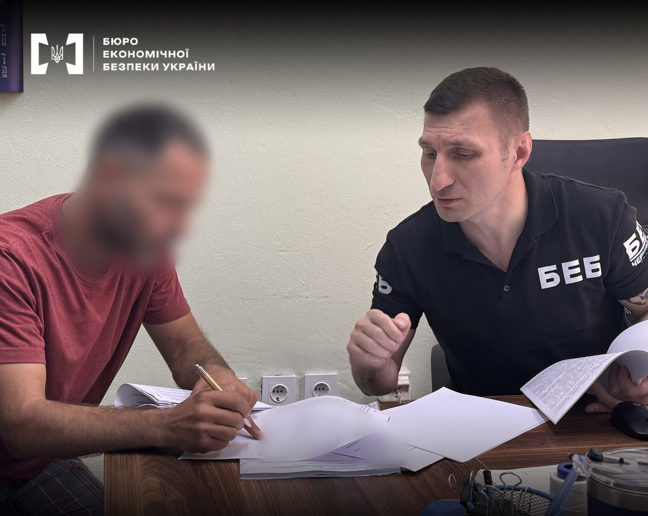 A ESBU detective conducts investigative actions. A man with a blurred face fills out papers with a pen. Official documents lie on the table.