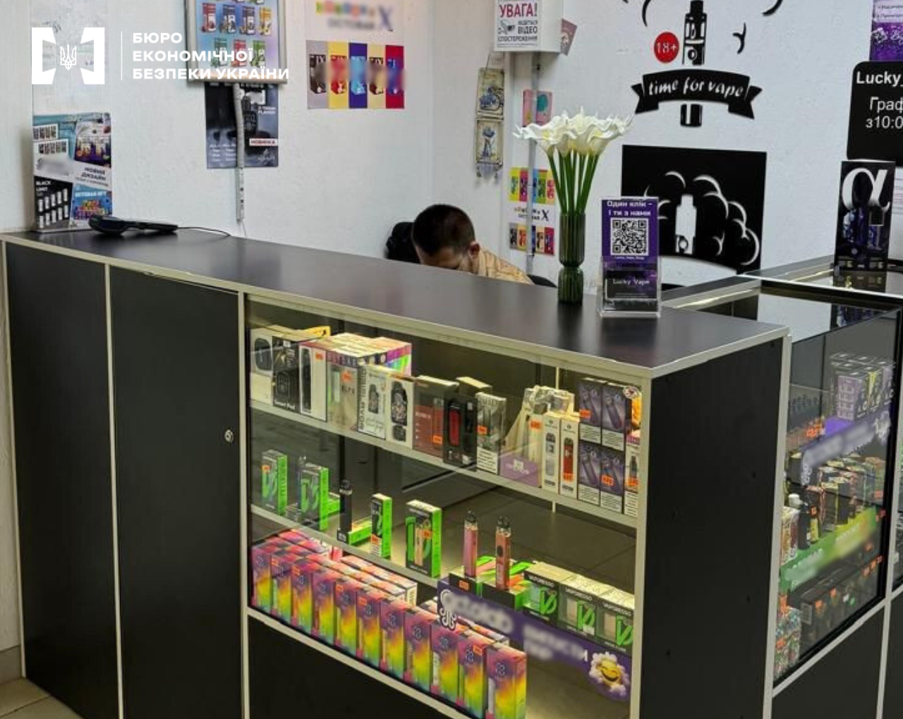 Interior of a vape shop with glass display cases filled with electronic smoking devices
