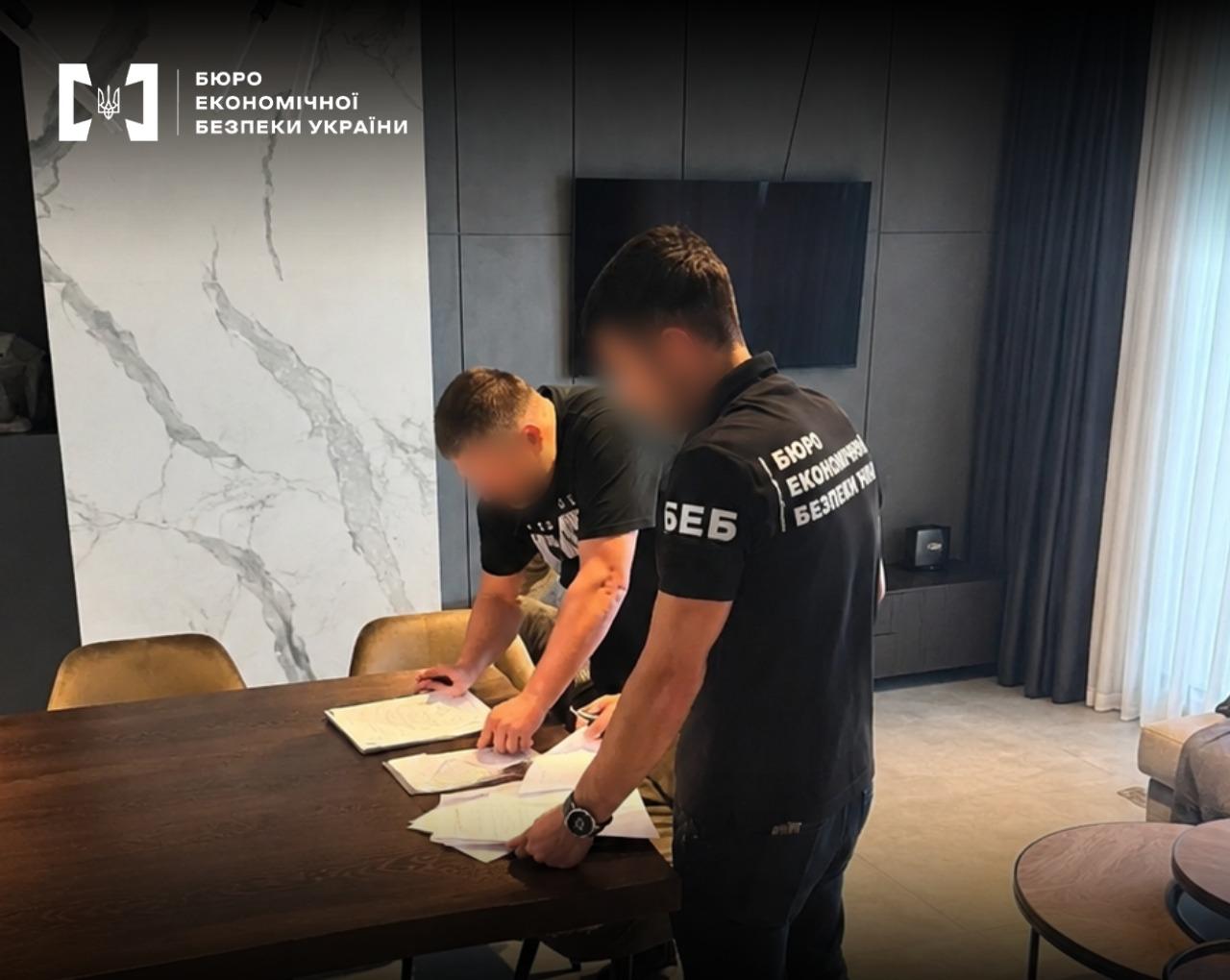 An ESBU detective is documenting the signing of documents during investigative actions in an office.