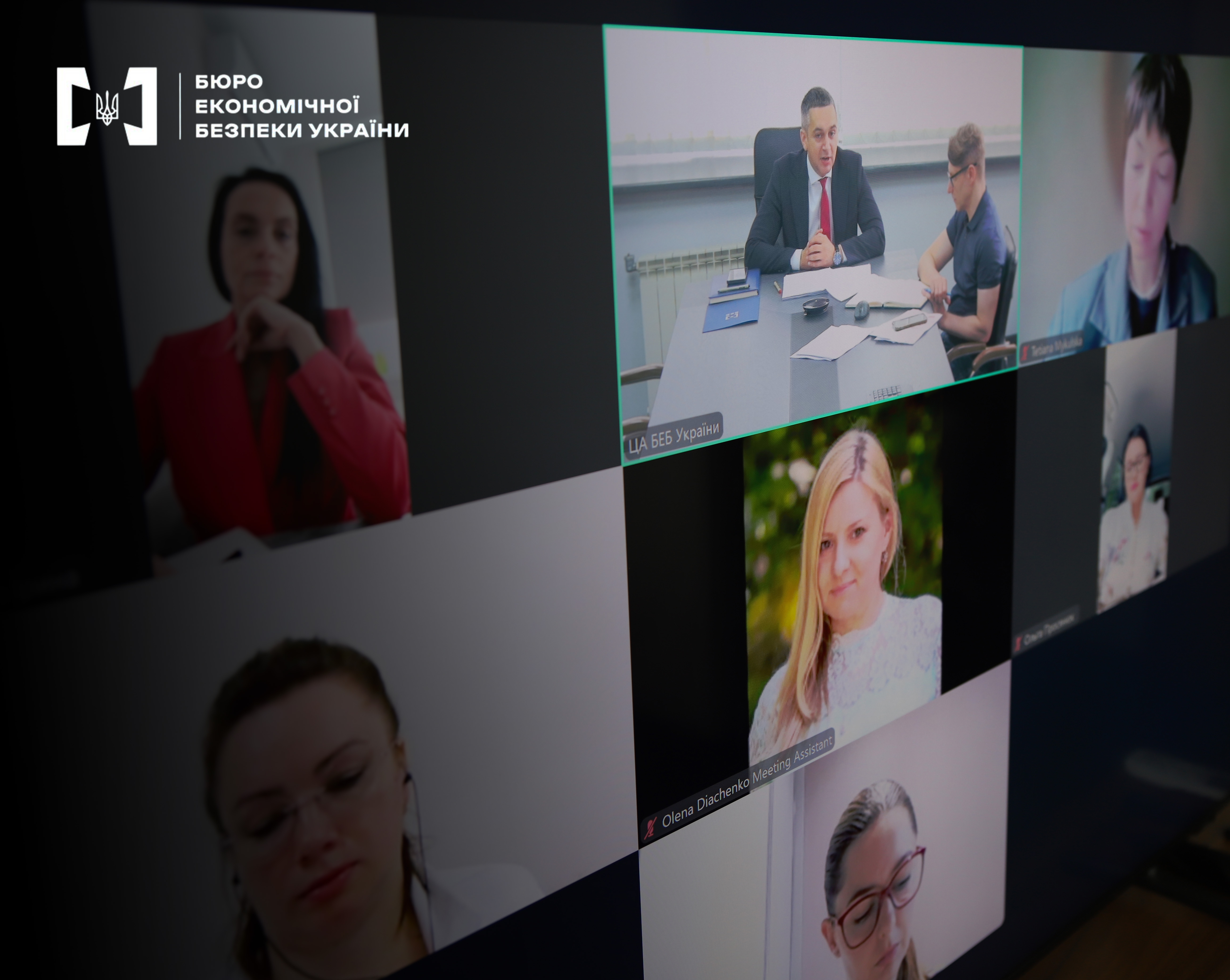 A monitor screen with online meeting windows and videoconference participants.