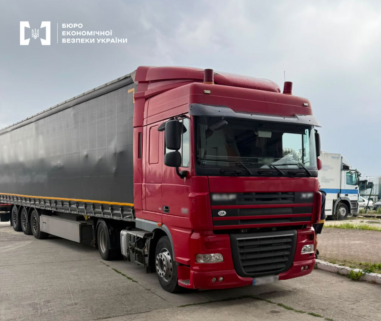 A large red DAF truck with a black curtain-sided semi-trailer.