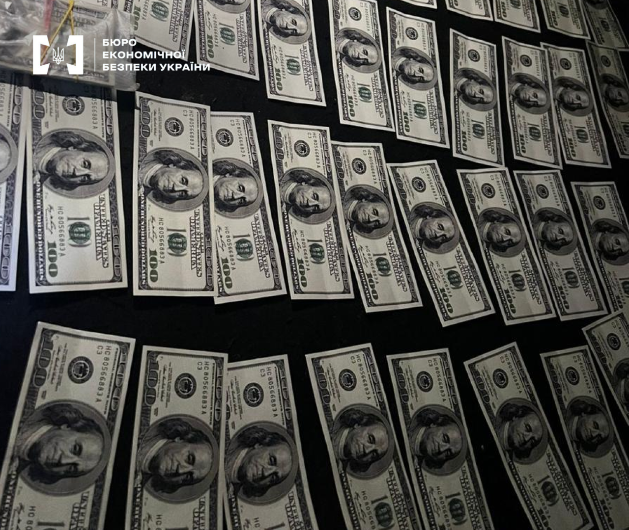 Cash foreign currency in US dollars arranged in rows on a dark surface.