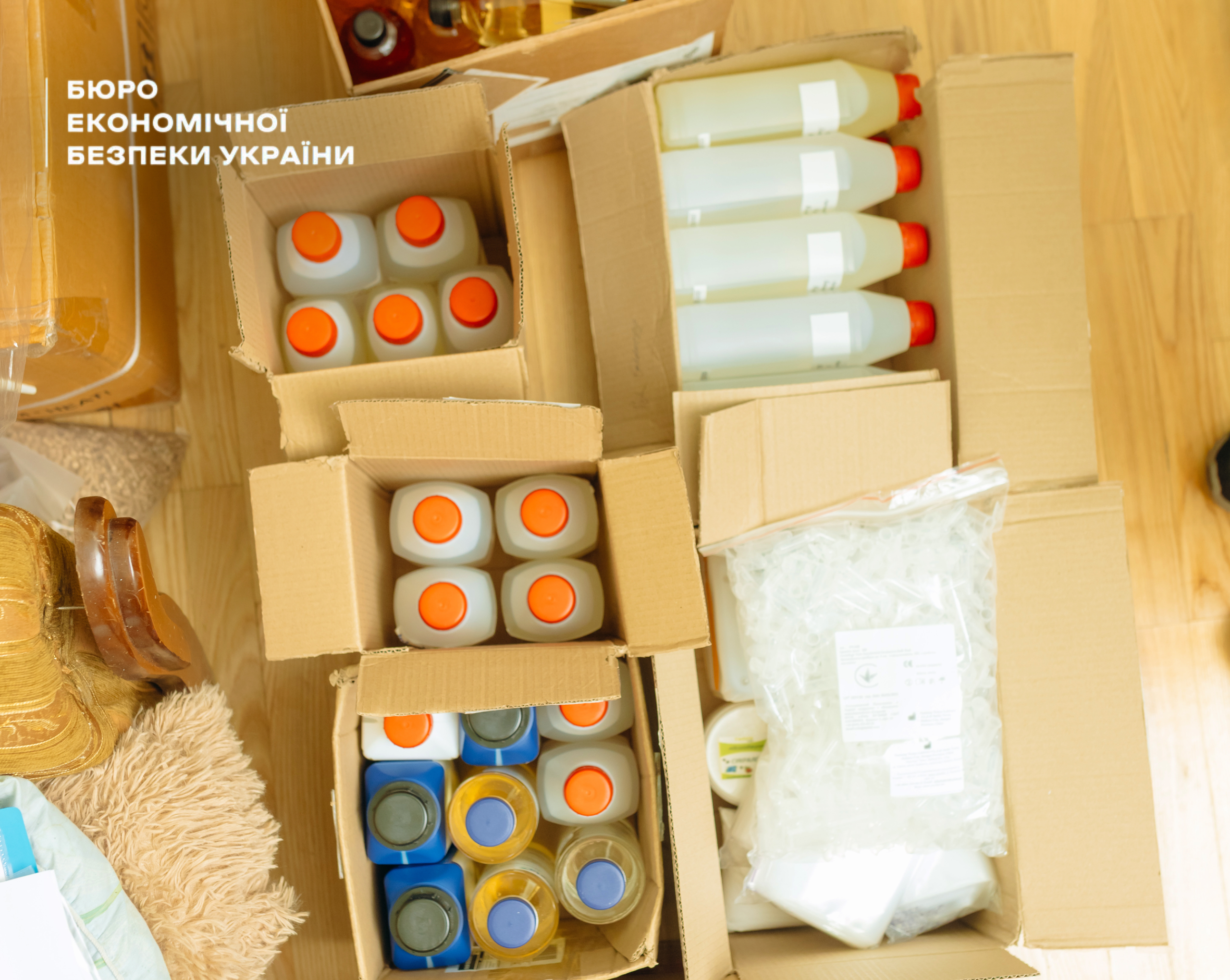 Cardboard boxes with plastic jerricans, bottles with liquid, and fittings.