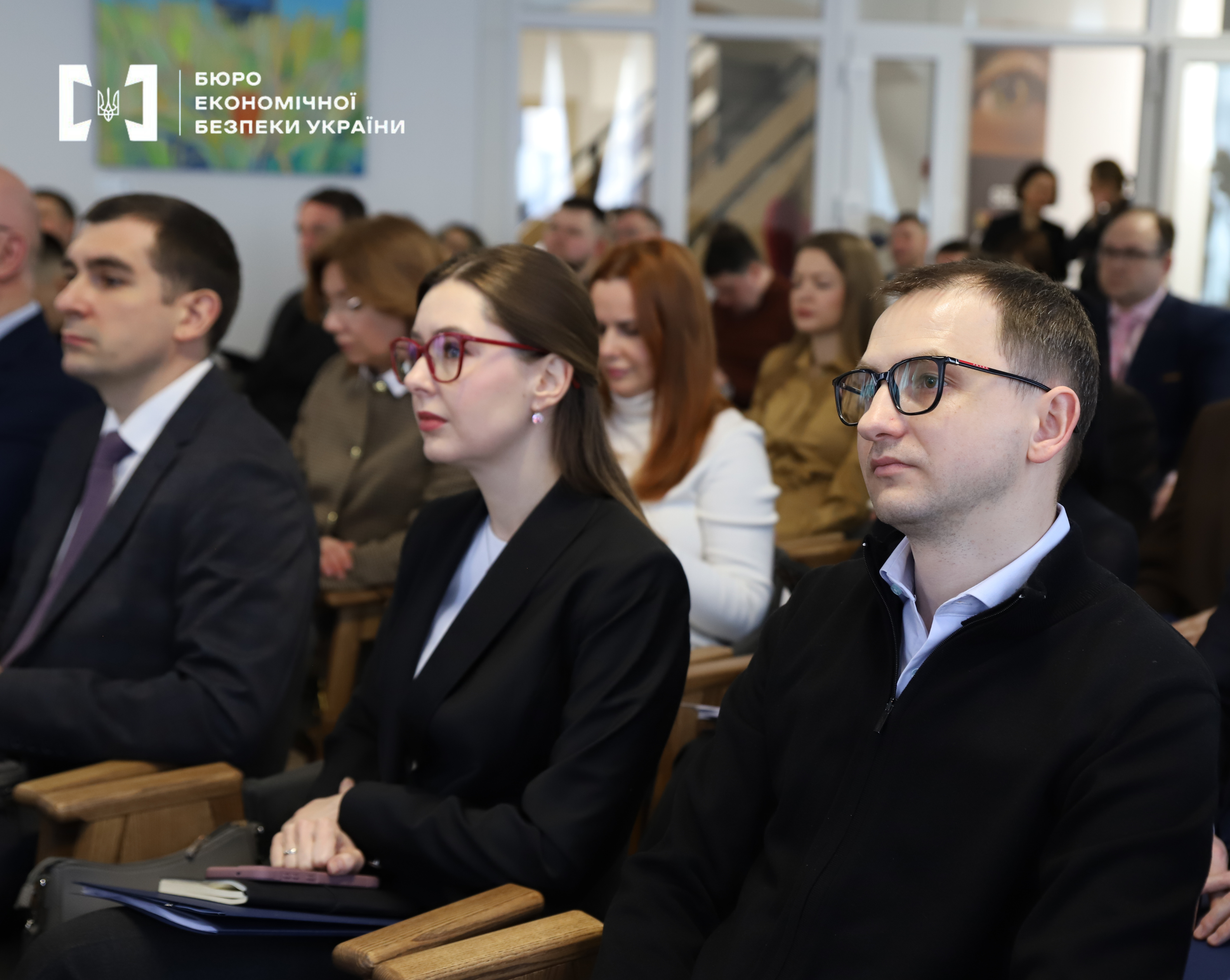 A group of people in a conference hall during an official event.