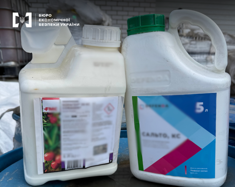 Two large white plastic canisters with agrochemicals standing in a warehouse.