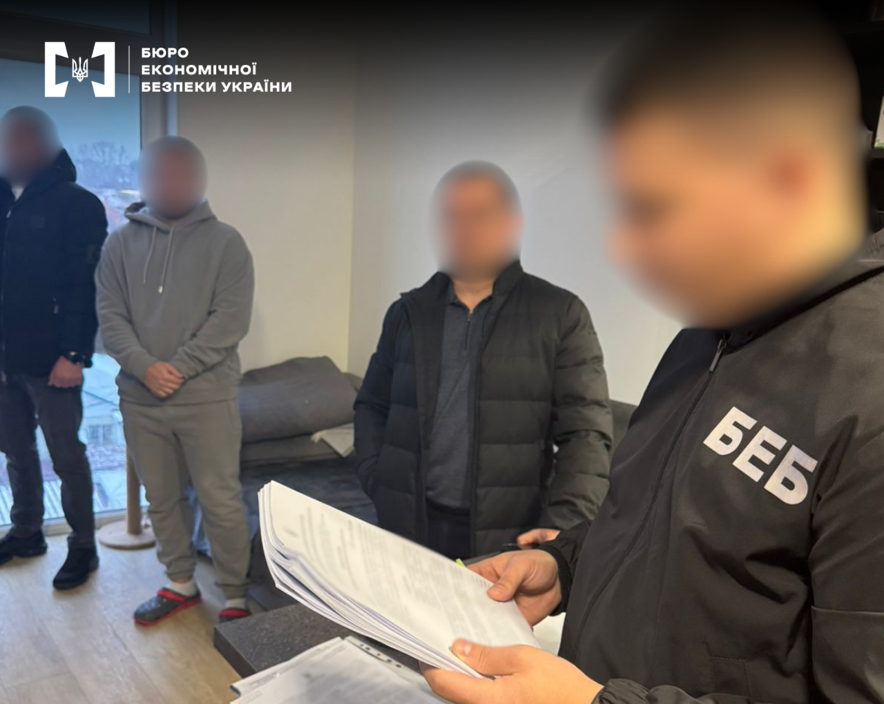 An ESBU detective serving a notice of suspicion or reading a court order in the presence of three citizens. Faces are hidden