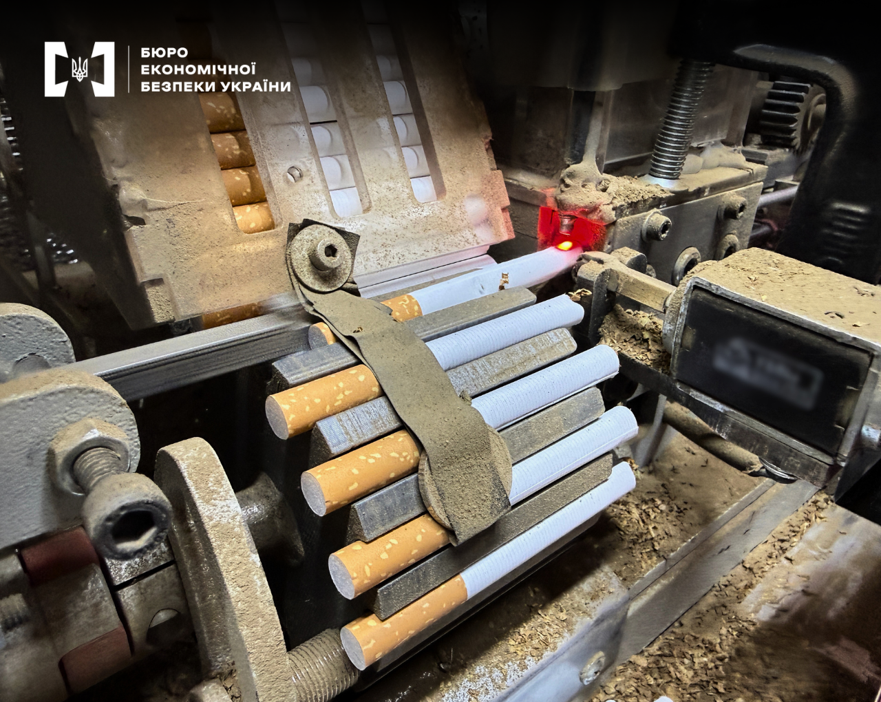 A close-up of an automatic cigarette production line operating on industrial equipment.