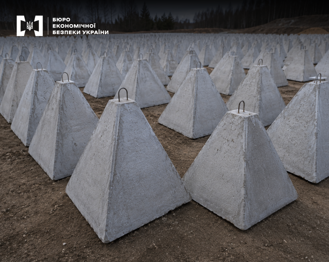 Rows of reinforced concrete anti-tank pyramids (dragon's teeth) on an open site.