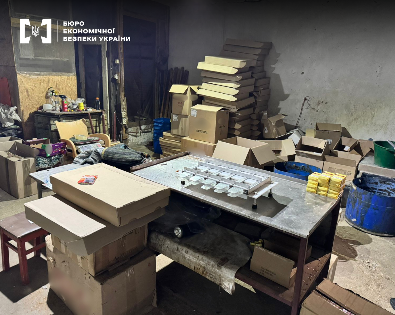 An underground production facility with a machine, cardboard boxes, and raw materials.