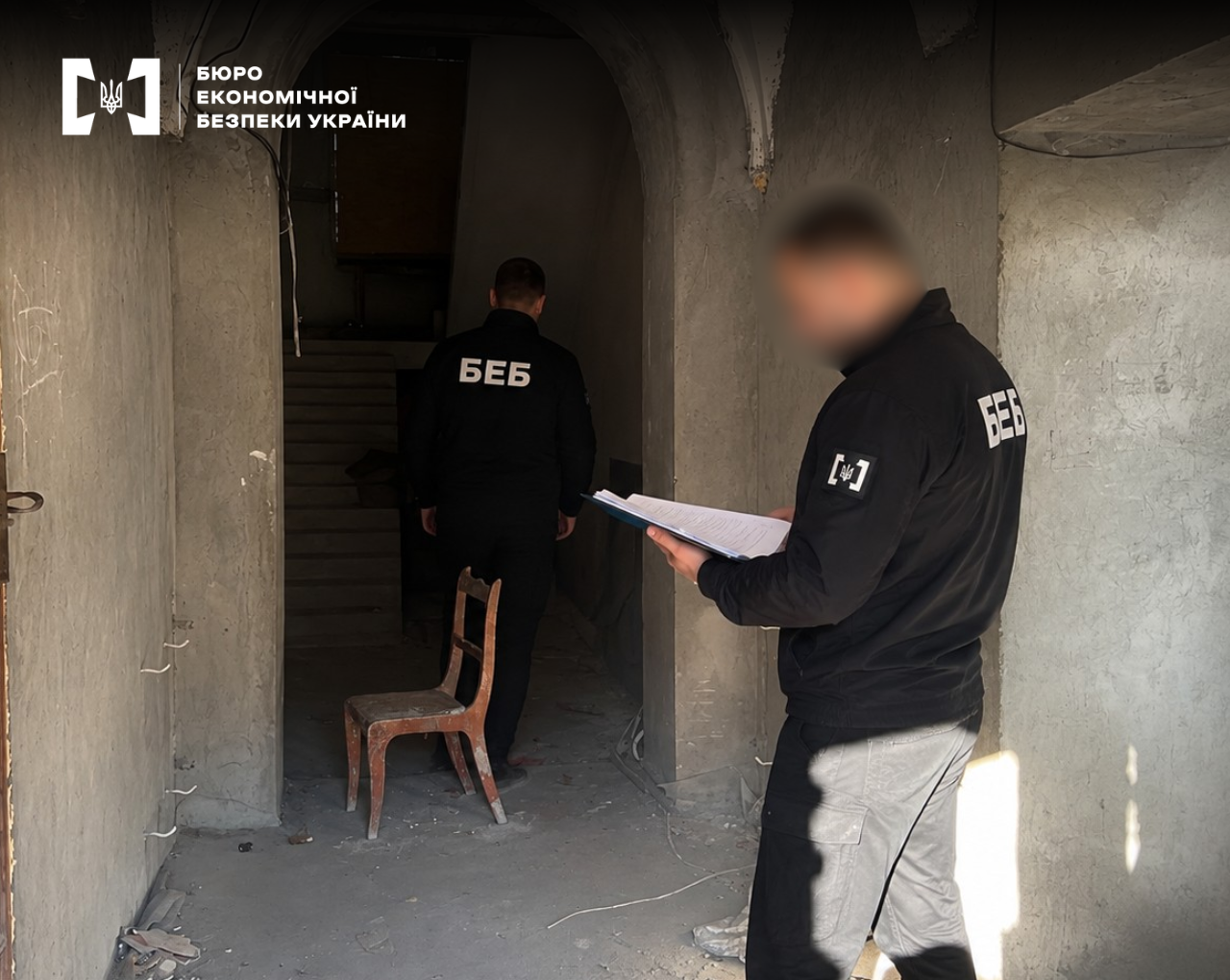 A ESBU detectives conduct investigative actions and record case materials in an unfinished concrete building.