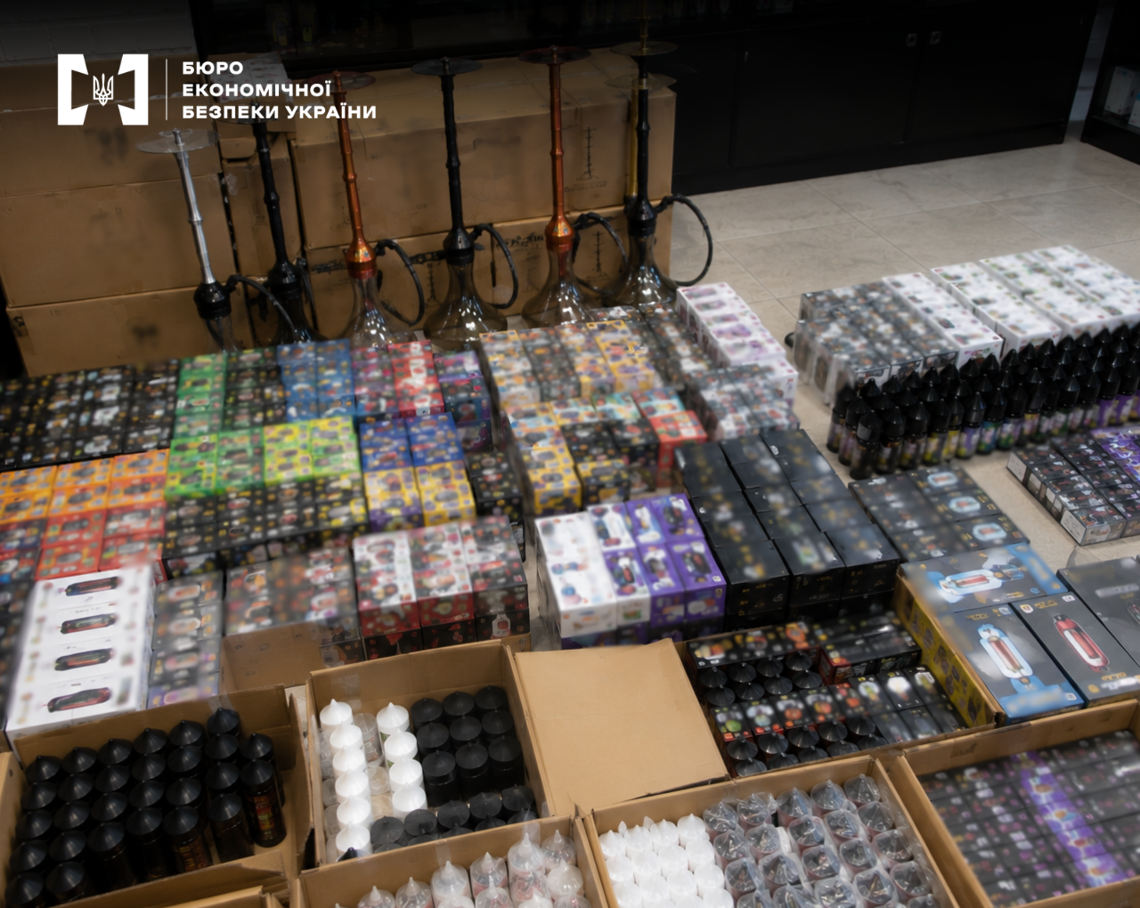 Hookahs, boxes of electronic cigarettes, refills, and vape liquids on the floor of a warehouse.