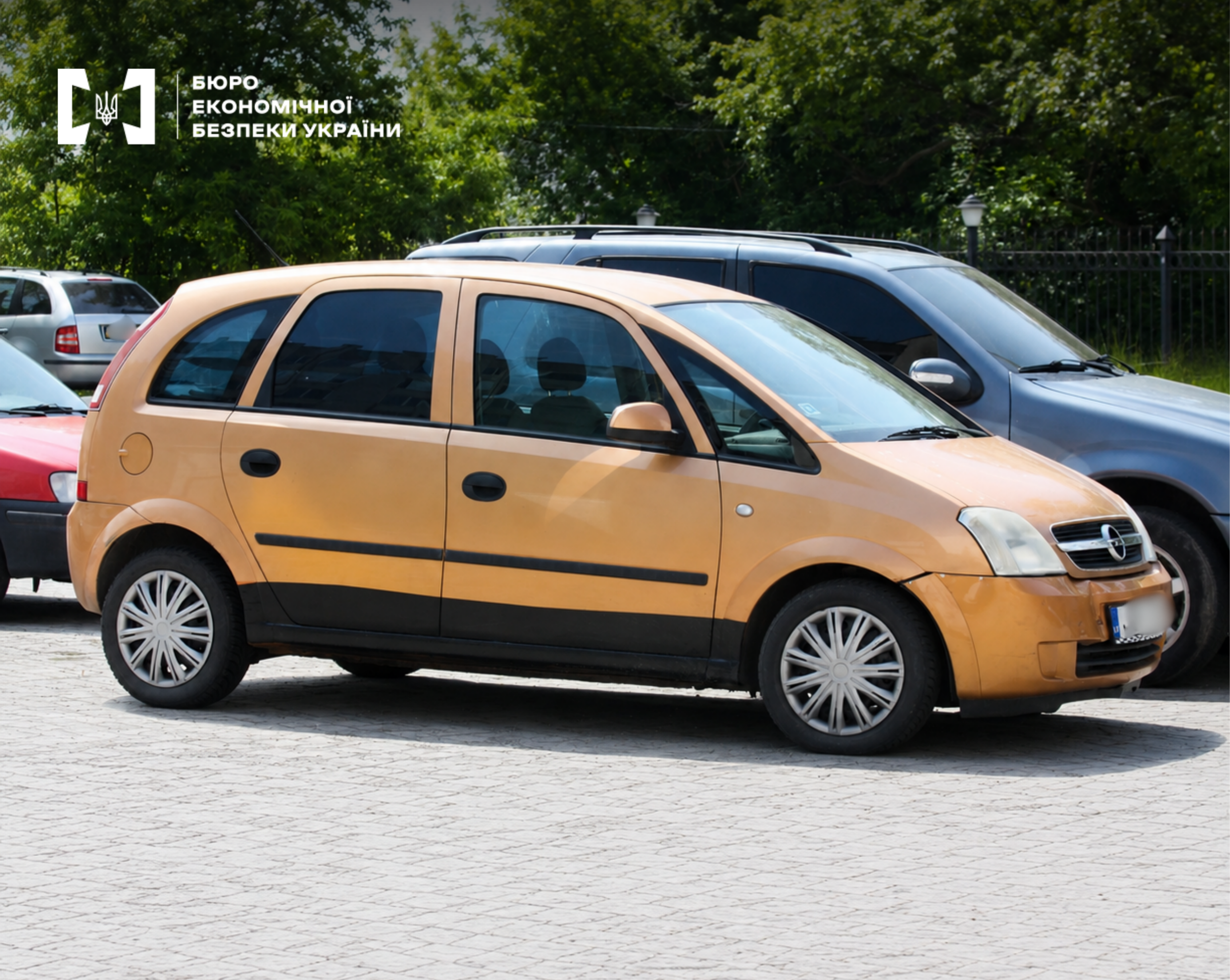 A gold-colored Opel passenger car parked in a parking lot