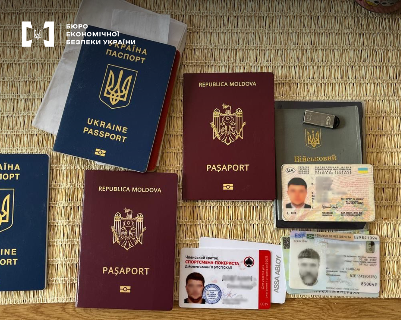 Passports of Ukraine, Moldova, and other personal documents (driving license, residence permit) spread out on a table.