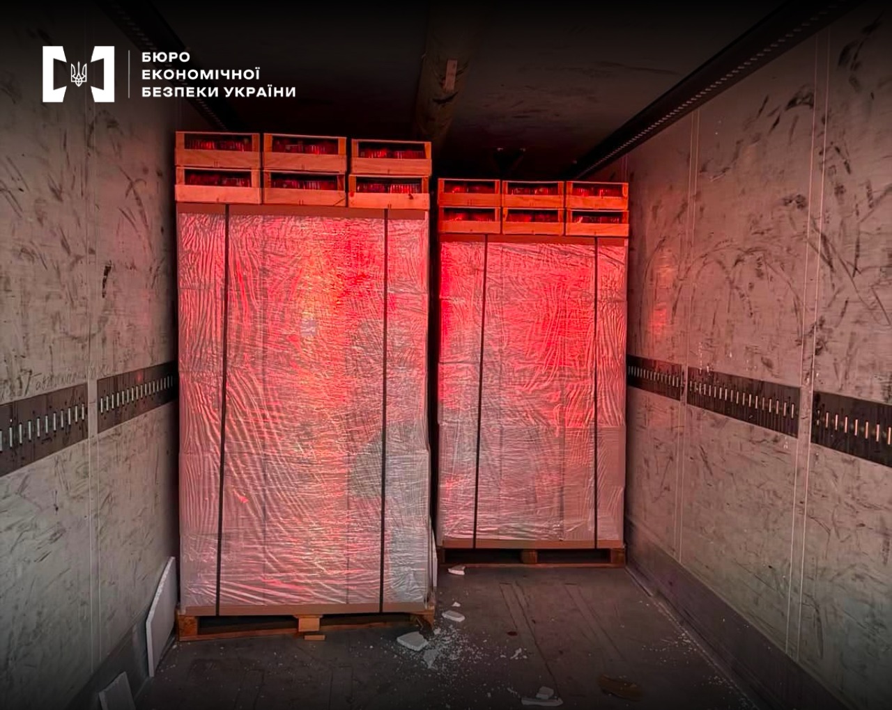 Two large pallets with film-wrapped boxes and wooden crates inside a truck.
