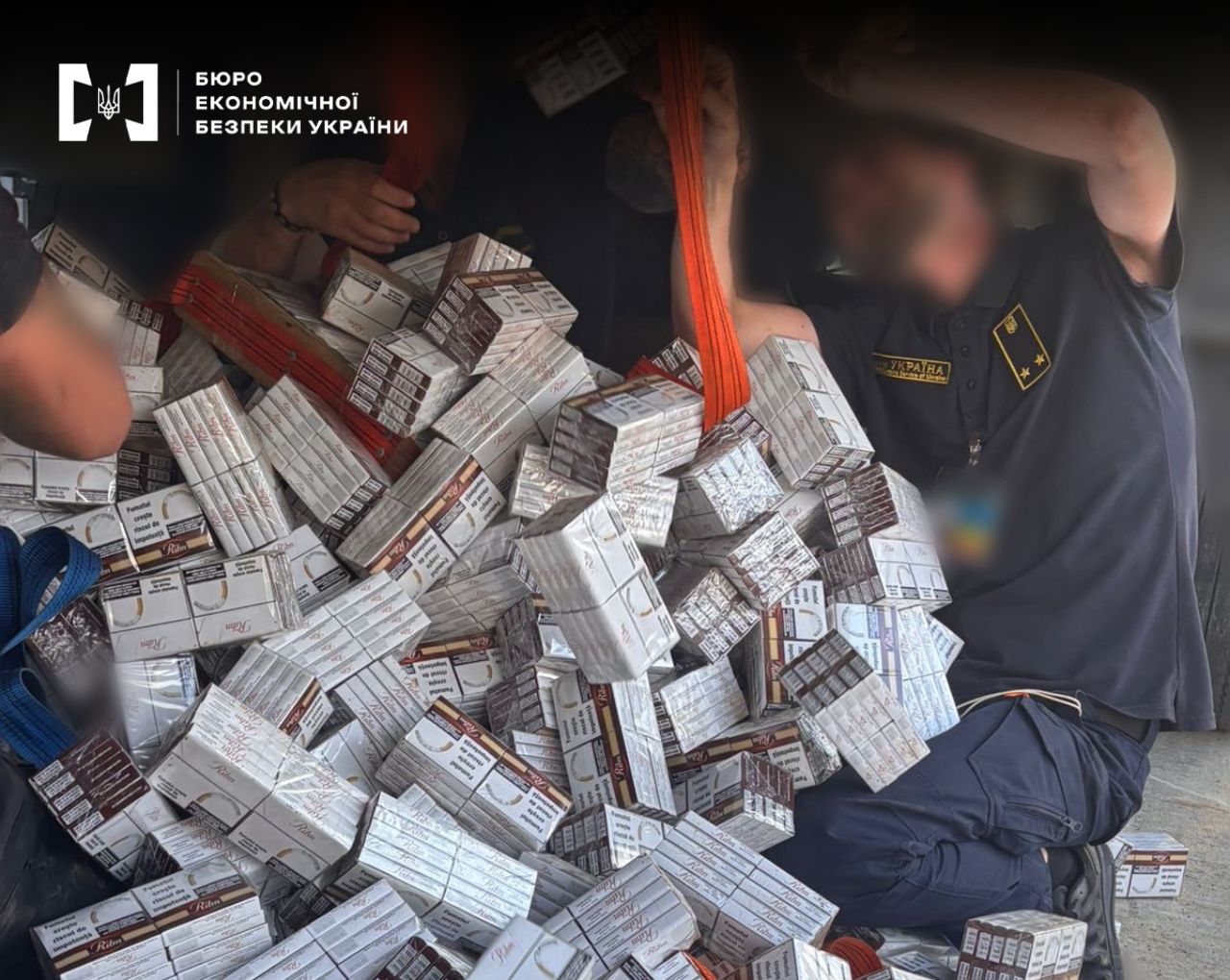 A ESBU detective records a huge pile of cartons of smuggled cigarettes in the body of a vehicle