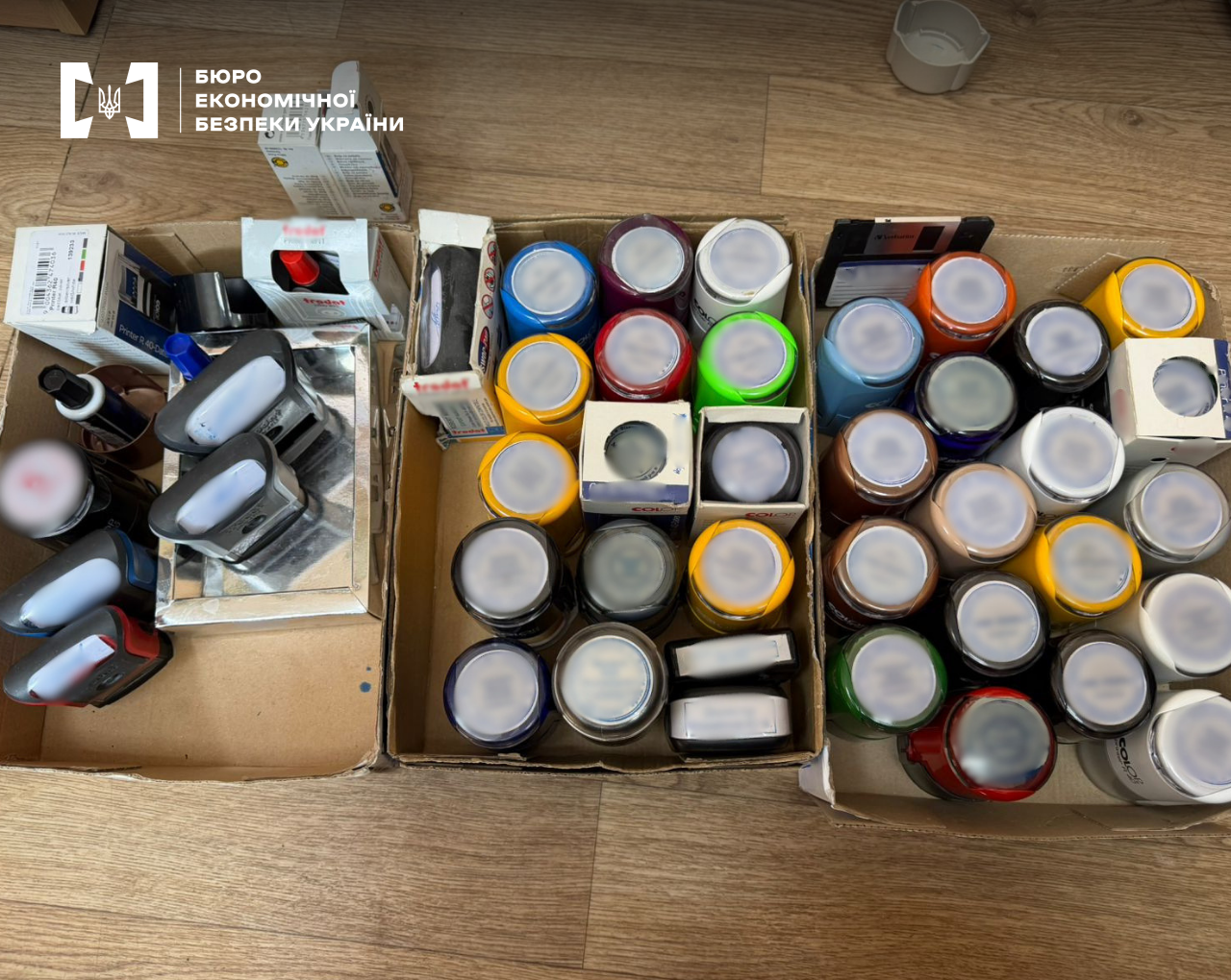 Three cardboard boxes completely filled with dozens of round and rectangular seals.