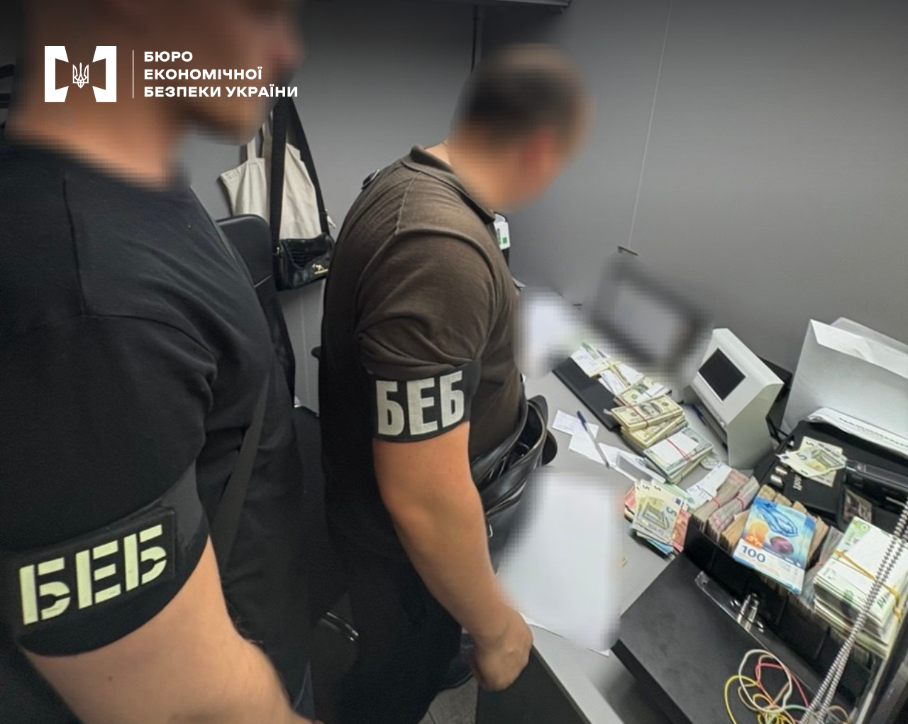 A ESBU detectives count large stacks of seized cash in hryvnias, dollars, and euros on a table.