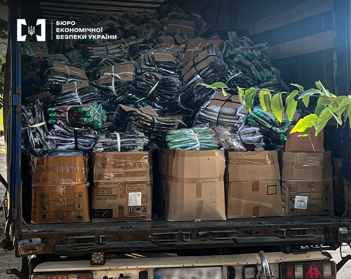 A truck bed completely filled with bundles of illegal sportswear and boxes.